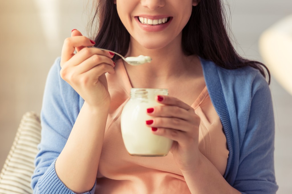 Mulher comendo iogurte Dieta low carb: reduza o carboidrato e volte a comer pão sem engordar