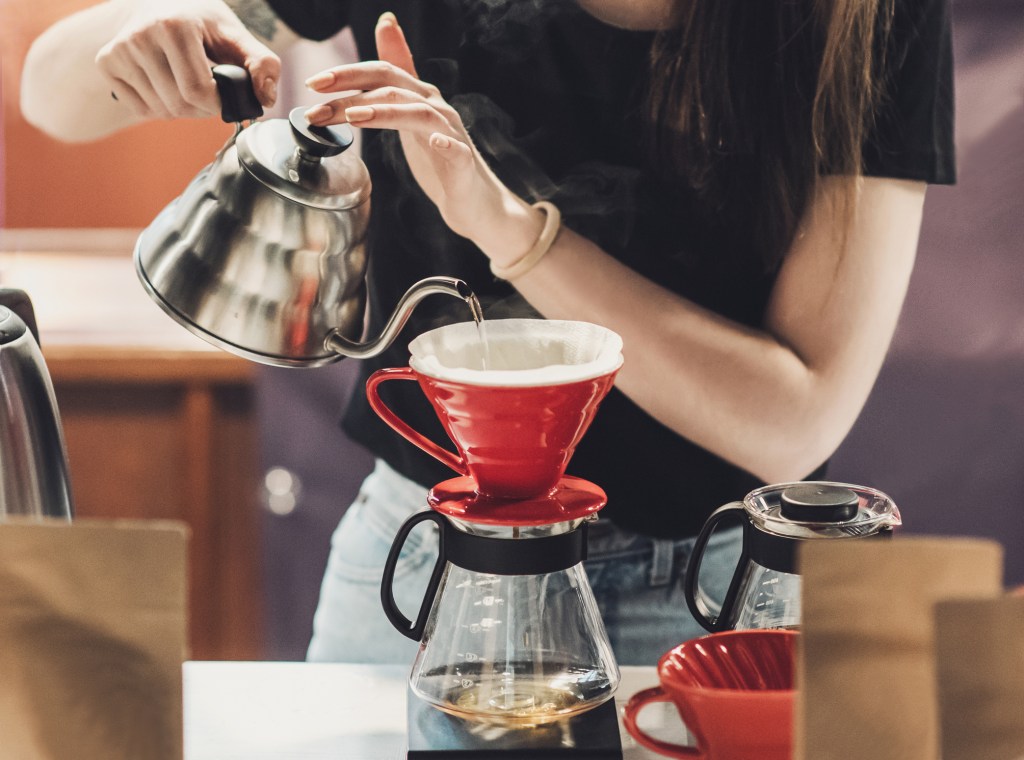 Young women barista at work in a cafe. Preparing pour over coffee Diferentes maneiras de começar o seu dia com café