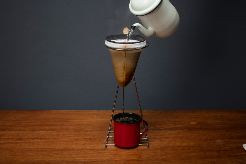 Xicara de café e coador de pano. Diferentes maneiras de começar o seu dia com café