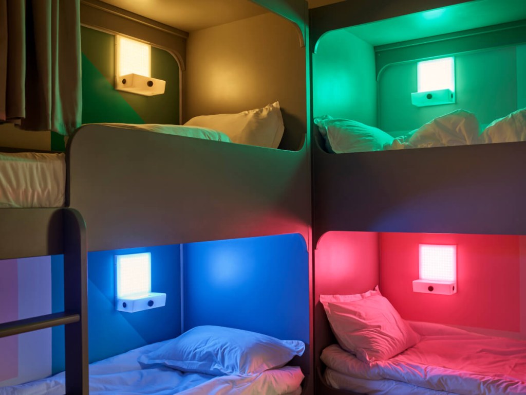 Iluminação cenográfica redefine atmosfera de hostel em Israel